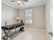 Bright home office with modern desk, plantation shutters, and light-colored walls at 751 Cajeput Loop, Tarpon Springs, FL 34689