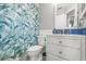 A stylish bathroom featuring a vanity with blue tile backsplash and tub with leaf-patterned shower curtain at 7591 121St Ter, Largo, FL 33773
