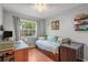 Cozy bedroom featuring daybed, wood floors, and a large window with natural light at 7591 121St Ter, Largo, FL 33773