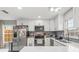 Modern kitchen with white cabinets, stainless steel appliances, backsplash, and a quartz countertop at 7591 121St Ter, Largo, FL 33773