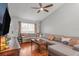 Comfortable living room boasts hardwood floors, vaulted ceilings, and a large sectional couch at 7591 121St Ter, Largo, FL 33773