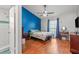 Bedroom featuring blue accent wall, ensuite bathroom, and hardwood floors at 7591 121St Ter, Largo, FL 33773