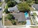 Aerial view of a home with a backyard pool, surrounded by green trees and neighborhood streets at 829 Riverside Dr, Tarpon Springs, FL 34689