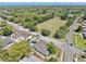 Aerial view of a neighborhood with mature trees, homes, a sports field, and a glimpse of the bay at 829 Riverside Dr, Tarpon Springs, FL 34689