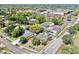Aerial view showcasing homes in a neighborhood with mature trees and nearby school buildings at 829 Riverside Dr, Tarpon Springs, FL 34689