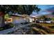 Charming single-story home at dusk featuring a well-maintained front yard, beautiful landscaping, and a welcoming entrance at 829 Riverside Dr, Tarpon Springs, FL 34689