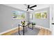 Bright office featuring a ceiling fan, large windows, and neutral walls and wood-look flooring at 829 Riverside Dr, Tarpon Springs, FL 34689