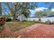 Cozy backyard featuring a brick patio, storage shed, and mature tree providing ample shade at 9611 107Th N Ave, Largo, FL 33773