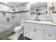 Modern bathroom with a glass-enclosed shower, white vanity, updated fixtures, and decorative mosaic tile at 9611 107Th N Ave, Largo, FL 33773