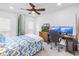 Bright bedroom with a ceiling fan, two windows, and workstation area with dual monitors at 9611 107Th N Ave, Largo, FL 33773