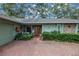Inviting front exterior featuring well-manicured landscaping, brick accents, and a cozy front porch at 9611 107Th N Ave, Largo, FL 33773