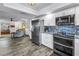 Modern kitchen with white cabinets, stainless appliances, and open to the cozy living room at 9611 107Th N Ave, Largo, FL 33773