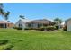 Expansive backyard featuring a screened lanai, well-maintained lawn and tropical landscaping at 987 Chickadee Dr, Venice, FL 34285