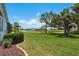 Lush backyard showcasing well-manicured lawn, scenic landscaping, and a serene view of the lake at 987 Chickadee Dr, Venice, FL 34285