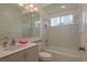 Bright bathroom featuring a vanity, large mirror, and combined toilet and bathtub with tiled wall at 987 Chickadee Dr, Venice, FL 34285
