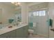Bright bathroom featuring modern vanity, glass-enclosed shower, toilet, and towel bars at 987 Chickadee Dr, Venice, FL 34285