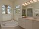 Bright bathroom with large tub, marble counters and natural light at 987 Chickadee Dr, Venice, FL 34285