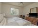 Cozy bedroom featuring a bed, desk, dresser with a TV, and a window with natural light at 987 Chickadee Dr, Venice, FL 34285