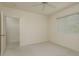 Well-lit bedroom featuring neutral walls, soft carpet, a window, and an open doorway to a closet at 987 Chickadee Dr, Venice, FL 34285