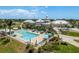 Community pool and clubhouse surrounded by lush landscaping, umbrellas, and lounge chairs at 987 Chickadee Dr, Venice, FL 34285
