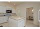 Bright kitchen with white cabinets, center island, and views to dining area at 987 Chickadee Dr, Venice, FL 34285
