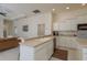 Bright kitchen with white cabinetry, tile flooring, and an open layout to the living area at 987 Chickadee Dr, Venice, FL 34285