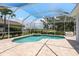 Inviting pool and jacuzzi in a screened-in enclosure overlooking lush landscaping and golf course at 987 Chickadee Dr, Venice, FL 34285