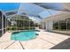 Enclosed pool area featuring a refreshing pool, jacuzzi, and tiled patio at 987 Chickadee Dr, Venice, FL 34285