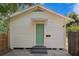 Exterior view of the home's backyard featuring a green door and fresh paint at 1003 E Emma St, Tampa, FL 33603