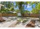 Extensive backyard showcasing a gravel patio, wooden deck, and lush greenery at 1003 E Emma St, Tampa, FL 33603