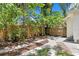 Landscaped backyard featuring decorative pavers, a privacy fence, and mature palm trees at 1003 E Emma St, Tampa, FL 33603