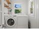 Laundry room featuring a modern washer and dryer, natural light, and ample storage space at 1003 E Emma St, Tampa, FL 33603