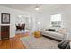 Bright living room showcasing hardwood floors, a comfortable sofa, and seamless flow to dining area at 1003 E Emma St, Tampa, FL 33603