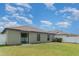Exterior view of the backyard showing the lush green lawn and the rear of the home at 10104 Carloway Hills Dr, Wimauma, FL 33598