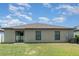 Exterior backyard with well-maintained lawn, sliding glass doors, and view of the house at 10104 Carloway Hills Dr, Wimauma, FL 33598