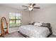 Clean, spacious bedroom with ample natural light, ceiling fan, and simple décor at 10104 Carloway Hills Dr, Wimauma, FL 33598