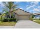 Charming one-story home featuring a well-maintained lawn and a spacious two-car garage at 10104 Carloway Hills Dr, Wimauma, FL 33598
