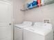 Functional laundry room equipped with a washer, dryer, and shelving for storage at 10104 Carloway Hills Dr, Wimauma, FL 33598