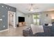Comfortable living room with tile flooring, a ceiling fan, and a large TV with decorative wall art at 10104 Carloway Hills Dr, Wimauma, FL 33598