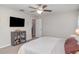 Simple main bedroom providing a serene space with natural light, desk and a small television at 10104 Carloway Hills Dr, Wimauma, FL 33598