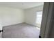 Bright bedroom features neutral walls and carpet, with natural light streaming through the window at 10123 Carp Hollow Rd, Sun City Center, FL 33573