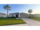 Charming single-story home featuring a manicured lawn and two-car garage at 10123 Carp Hollow Rd, Sun City Center, FL 33573