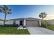 Charming single-story home featuring a manicured lawn and two-car garage at 10123 Carp Hollow Rd, Sun City Center, FL 33573