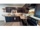 Efficiently designed kitchen with black appliances, dark cabinets and wood-look flooring at 10123 Carp Hollow Rd, Sun City Center, FL 33573