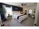 A beautifully staged primary bedroom with a king bed, dark accent wall and carpeted floors at 10123 Carp Hollow Rd, Sun City Center, FL 33573