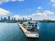 An eye-level aerial view captures a modern pier extending into the blue water, set against a skyline backdrop at 10340 2Nd N Way, St Petersburg, FL 33716