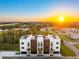 Stunning aerial view of modern townhomes with rooftop terraces and a vibrant sunset backdrop at 10340 2Nd N Way, St Petersburg, FL 33716