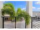 A modern balcony offers outdoor living space with sleek black railings and a view of palm trees against a blue sky at 10340 2Nd N Way, St Petersburg, FL 33716