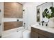 Modern bathroom featuring decorative tile, dark accents, glass shower door, and bright white countertops at 10340 2Nd N Way, St Petersburg, FL 33716