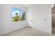 A white bedroom offers ample natural light from a large window, with light-colored floors and a closet at 10340 2Nd N Way, St Petersburg, FL 33716